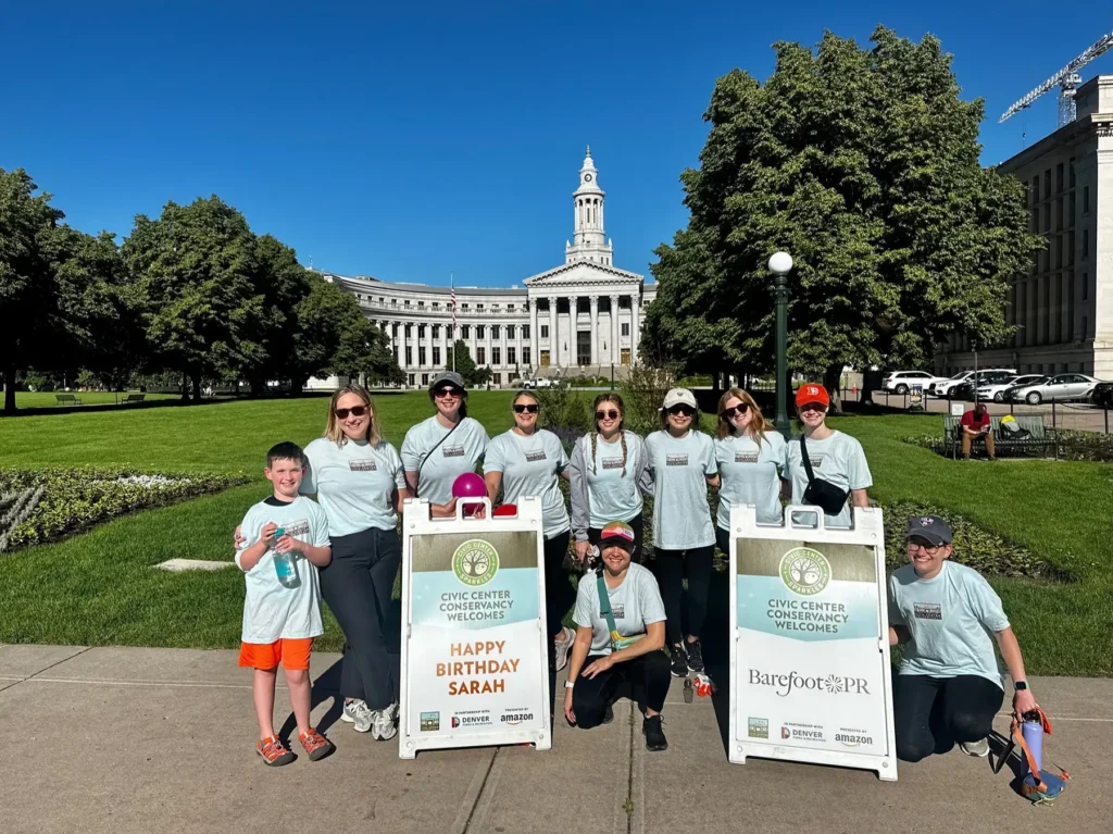 The Barefoot team gathers in front of the civic center park on a sunny day.