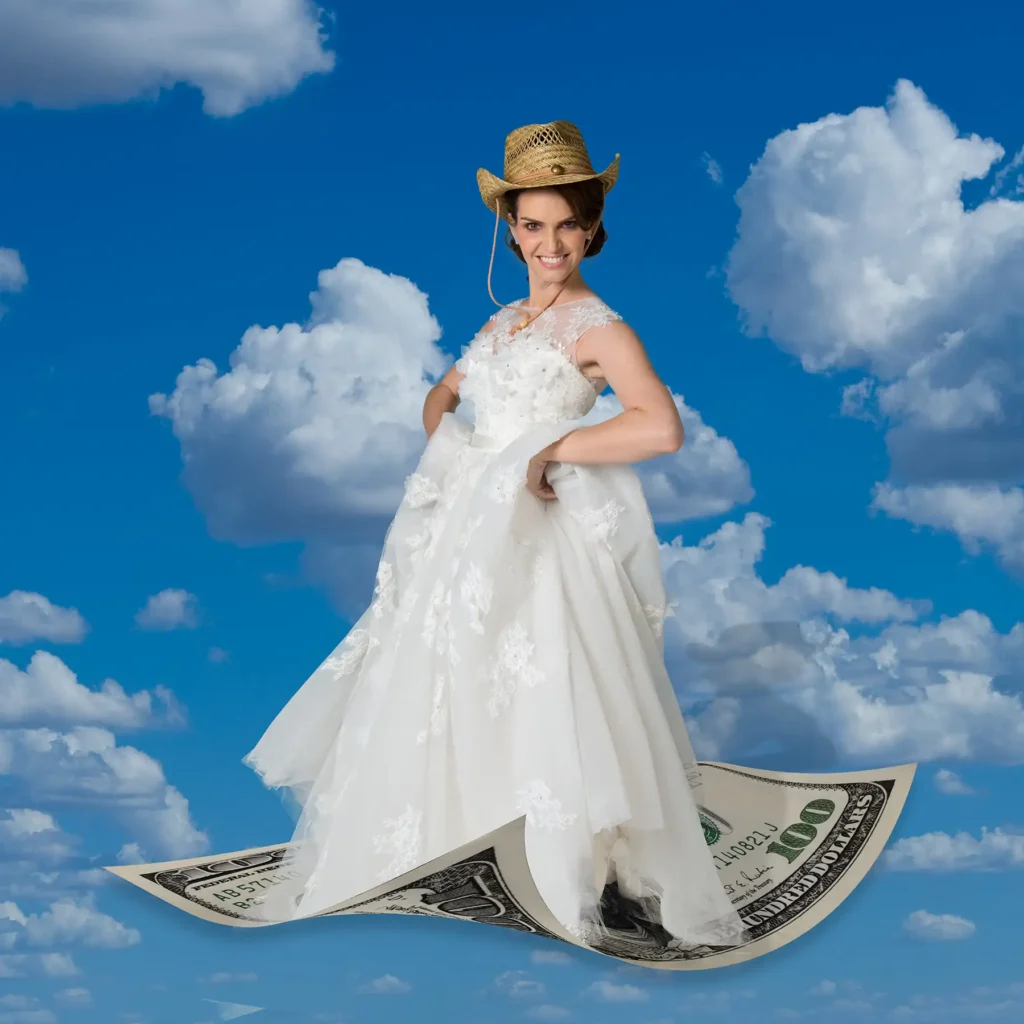 Stock image of a woman wearing a wedding dress, straw hat, riding a $100 bill that is floating in a blue sky with clouds.