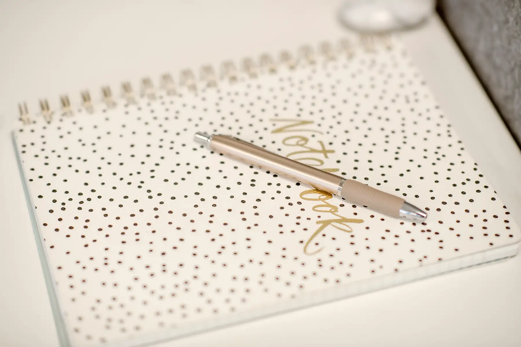 A cover of a notebook with gold polka dots on it.