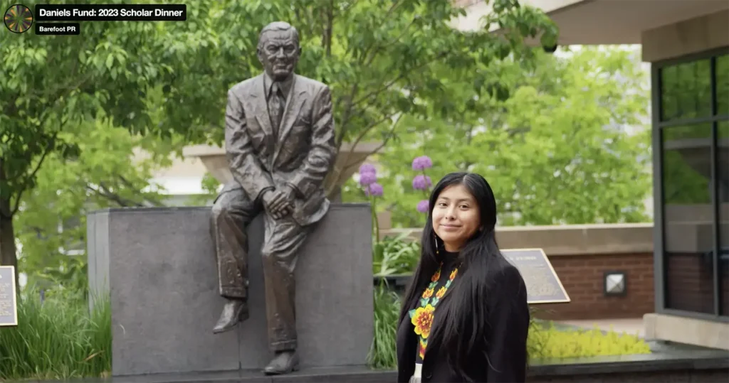 A girl stands in front of a statue