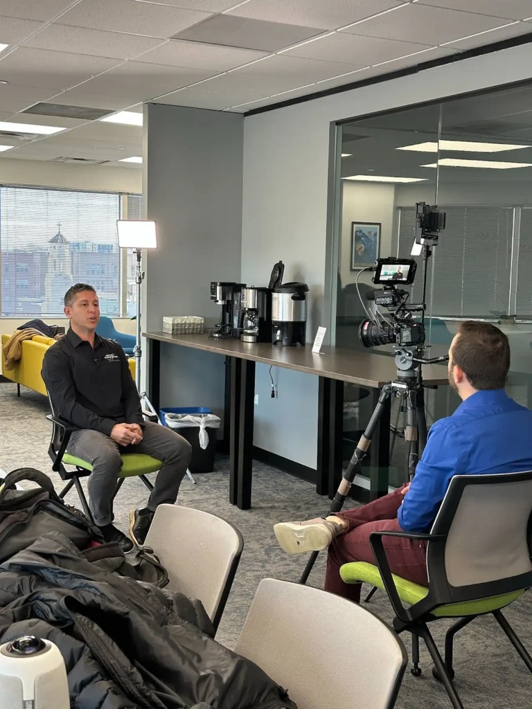 A camera interview is set up in an office space between a reporter from the Denver7 and the director of lending from Colorado Enterprise Fund (CEF).