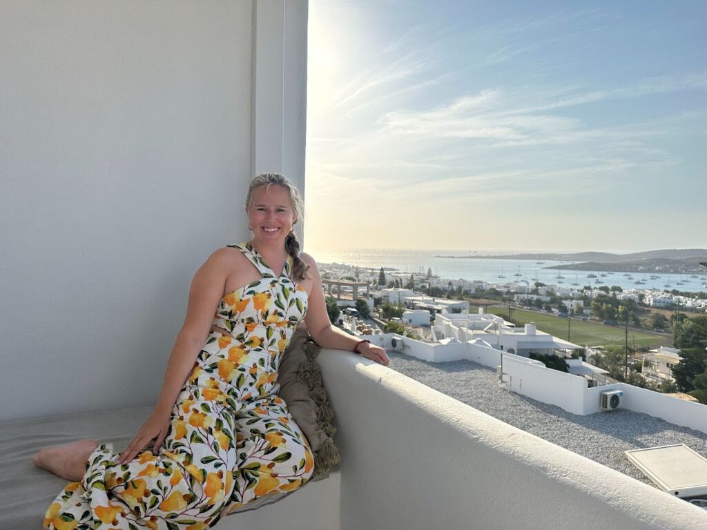 Carlie laying on a bench on a sunny day overlooking the ocean