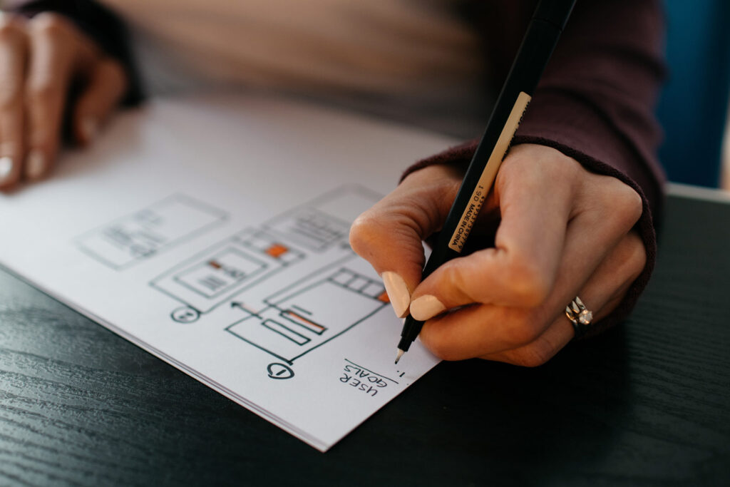 A woman writing user goals on a piece of paper