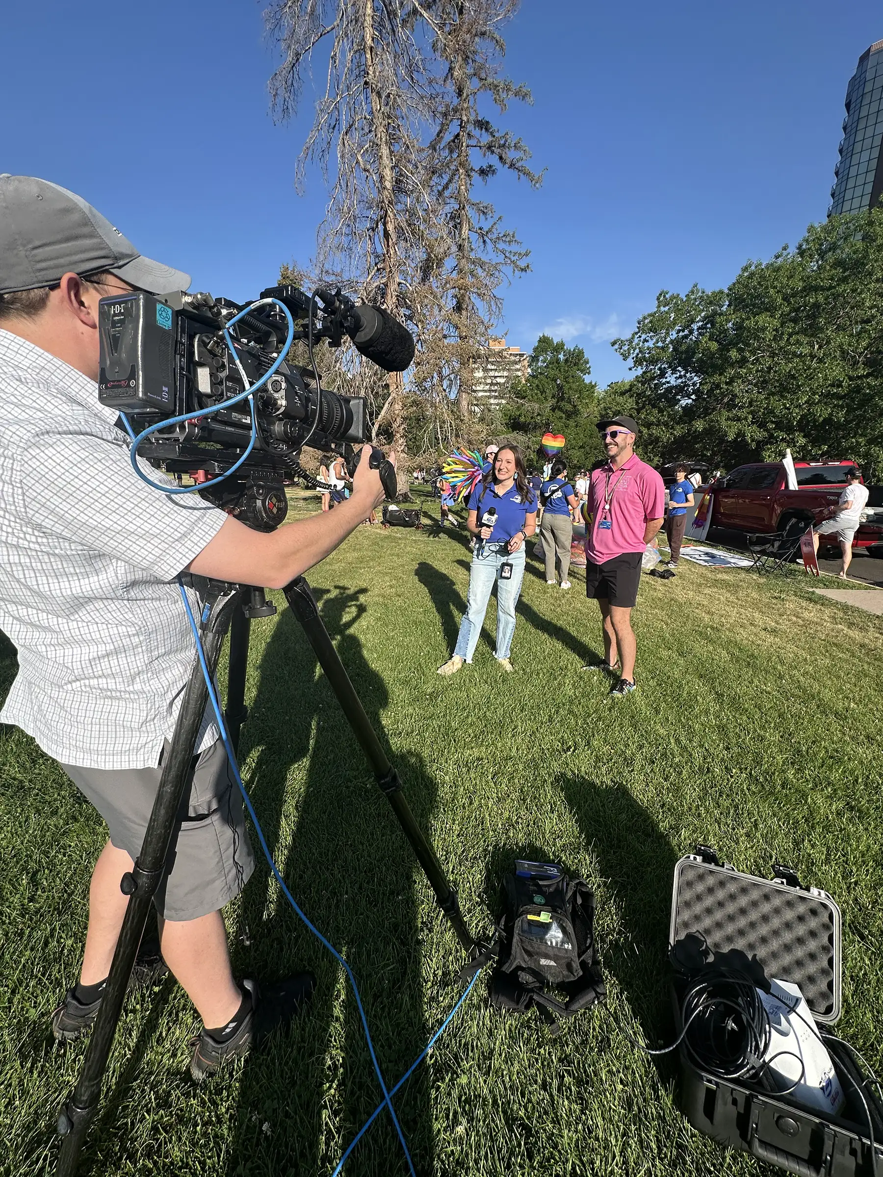 A woman is being interviewed by a camera crew at a Denver pride event