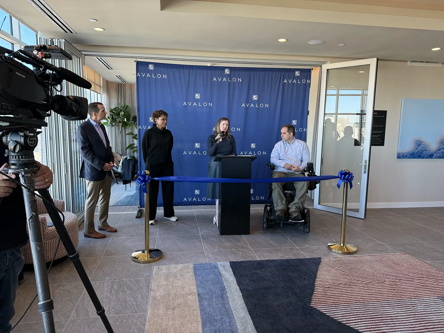 Sara Hazel, President and CEO of DPS Foundation, speaking at a podium in front of a backdrop with the "Avalon" logo