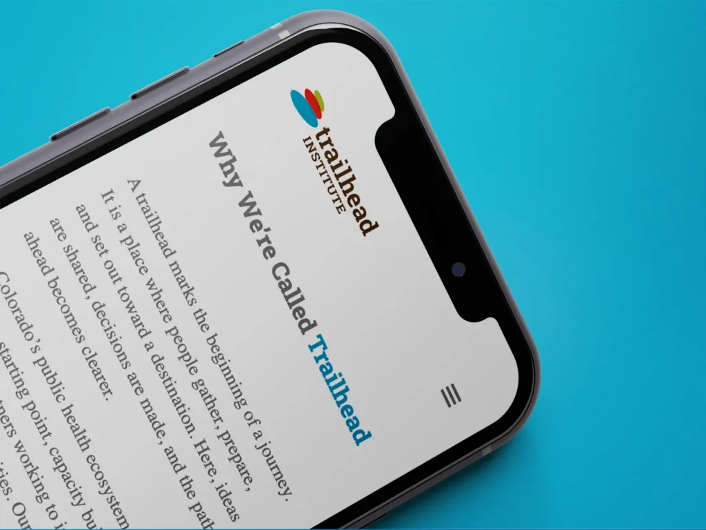 A phone displaying Trailhead's website, a section titled "Why We're Called Trailhead"