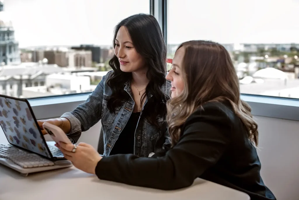 Two Barefoot team members looking at something on a laptop