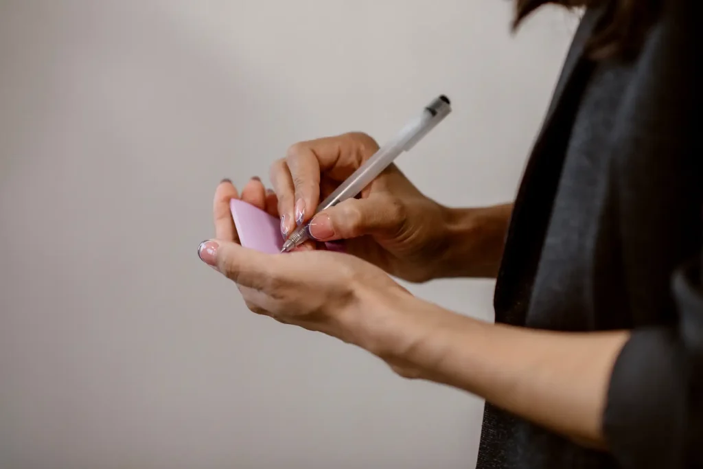 A woman writes on a sticky note